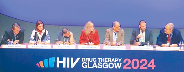 A landscape photo of seven people sitting in a line at a table, forming a panel at the 2024 HIV Drug Therapy Glasgow Conference. Left to right, they are, Victor Babes, Cristiana Oprea, Luís Mendão, Catia Marzolini, Esteban Martínez, Juan Ambrosioni and Jürgen Rockstroh.