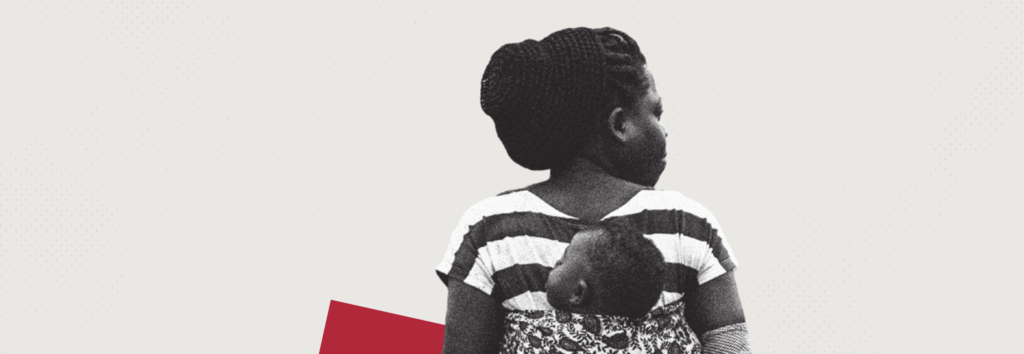 A black and white photographic image of a Black woman carrying a baby on her back, on a light grey background. The photo shows her from head to mid-torso and is taken from behind. Her head is turned to the right whilst her baby’s is turned to the left. Her hair is in braids that have been styled into a bun and she is wearing a striped t-shirt.